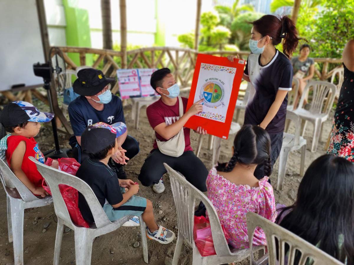 Mico (in red) teaching children about balanced nutrition.