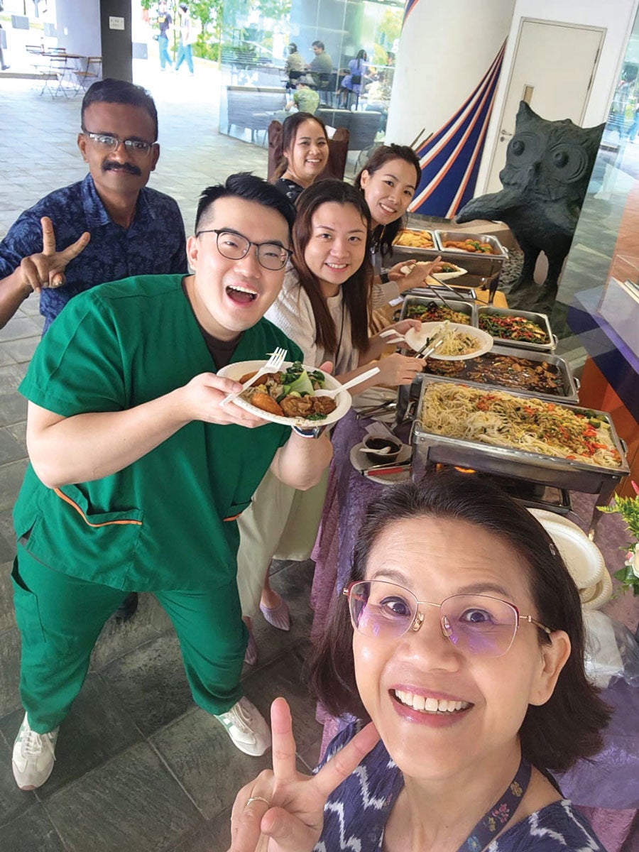 Dr Lim and Dr Tan with students at a buffet posing for a group shot.