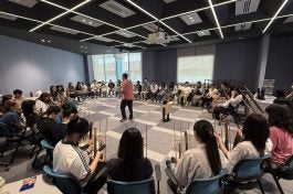 Students explore the connection between music and the elderly by trying out the Angklung
