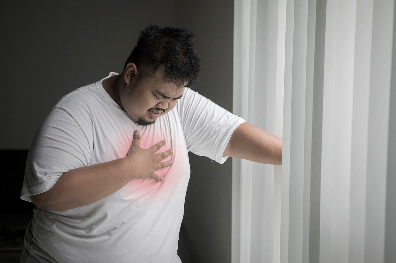 Obese man having a heart attack near the window