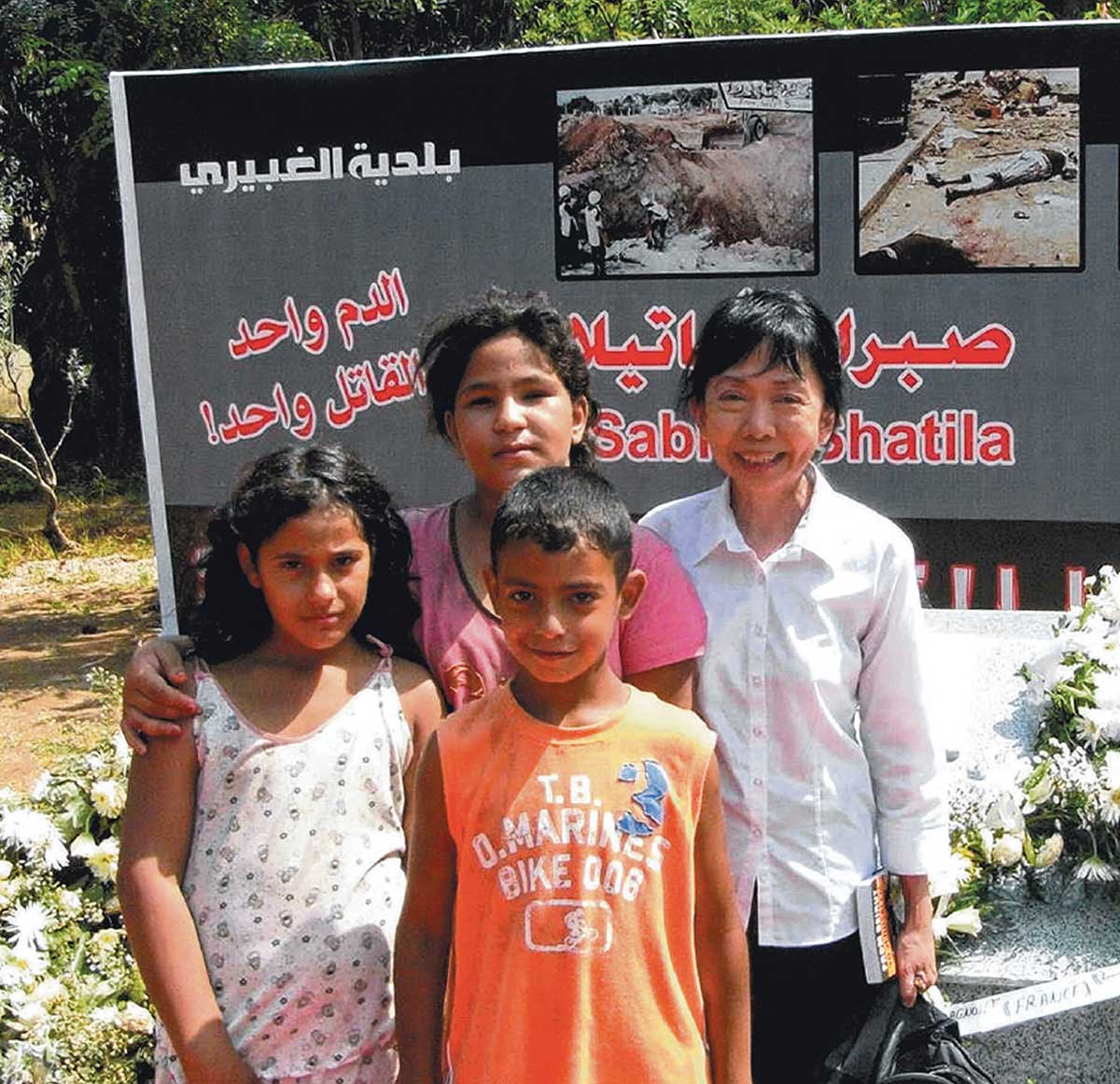 Dr Ang Swee Chai with three young persons outside Shatila refugee camp