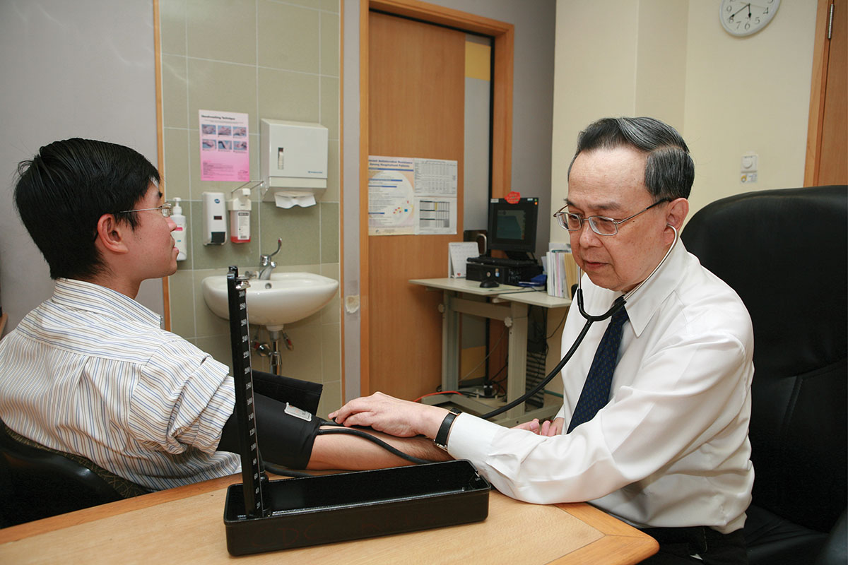 Professor Chia Boon Lock measuring the blood pressure of a young adult patient.