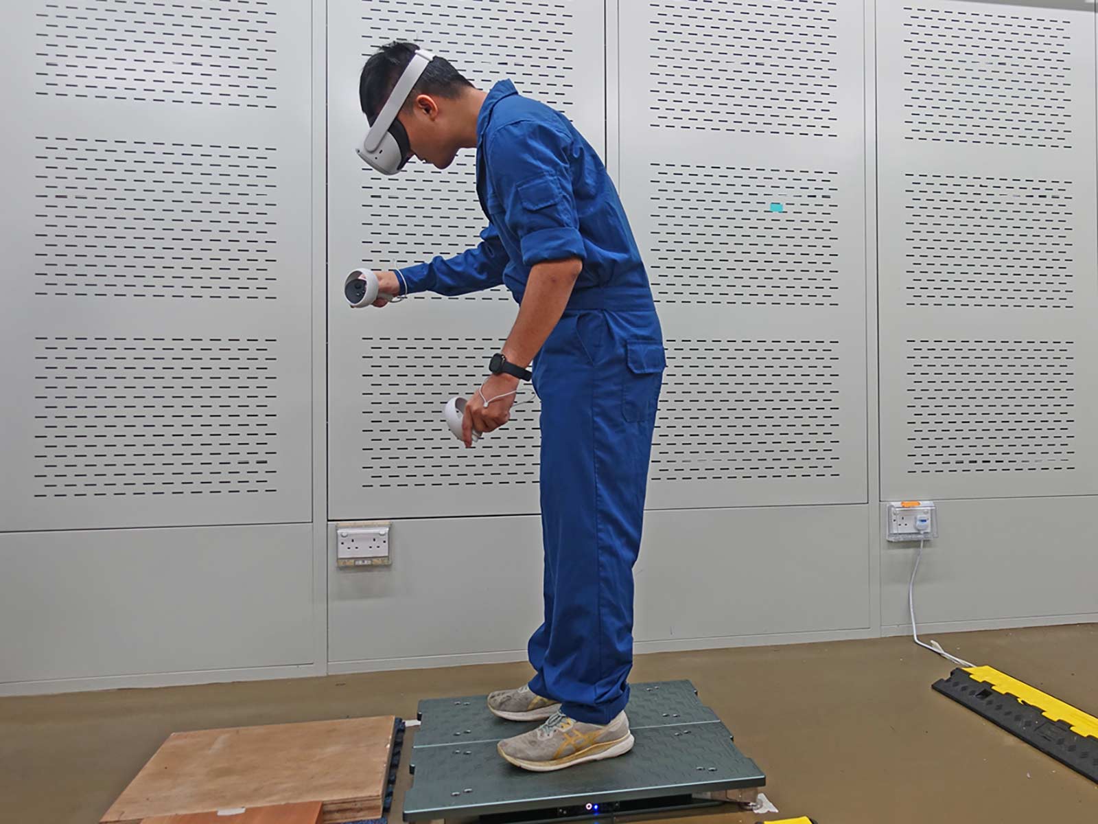 A participant completing a welding simulation task using a virtual reality headset in the climatic chamber.