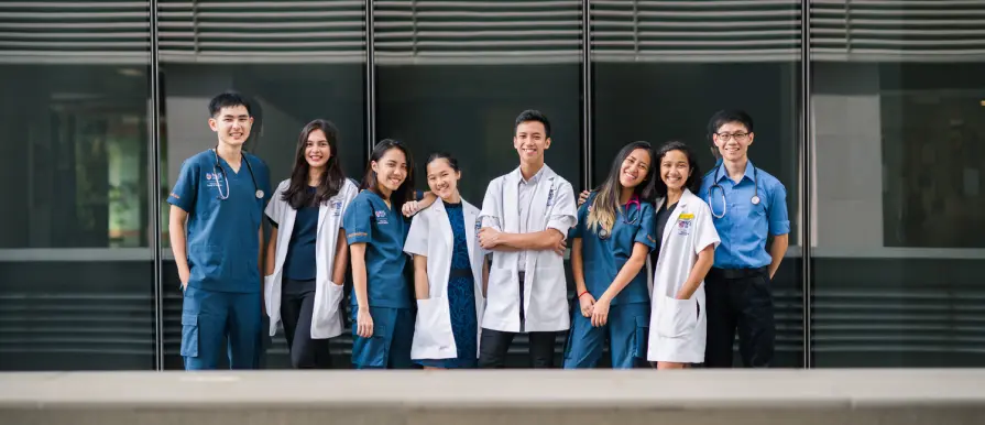 NUS MBBS programme students in medical attire on campus