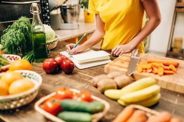 Woman in a kitchen setting with ingredients on the table to represent the Clinical Nutrition Research Centre, CNRC