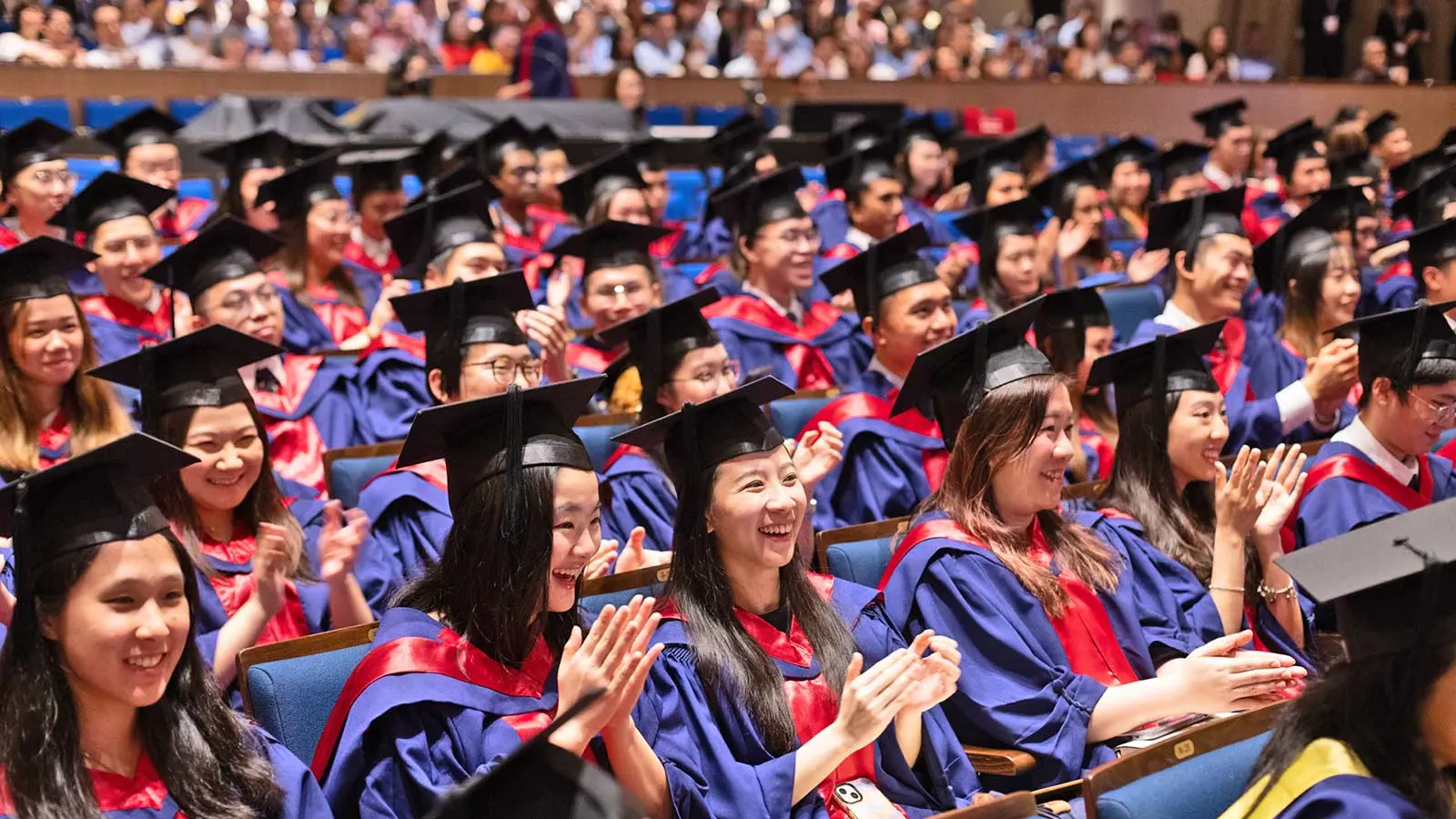 NUS Medicine Class of 2024 in the audience cheering their peers on stage.