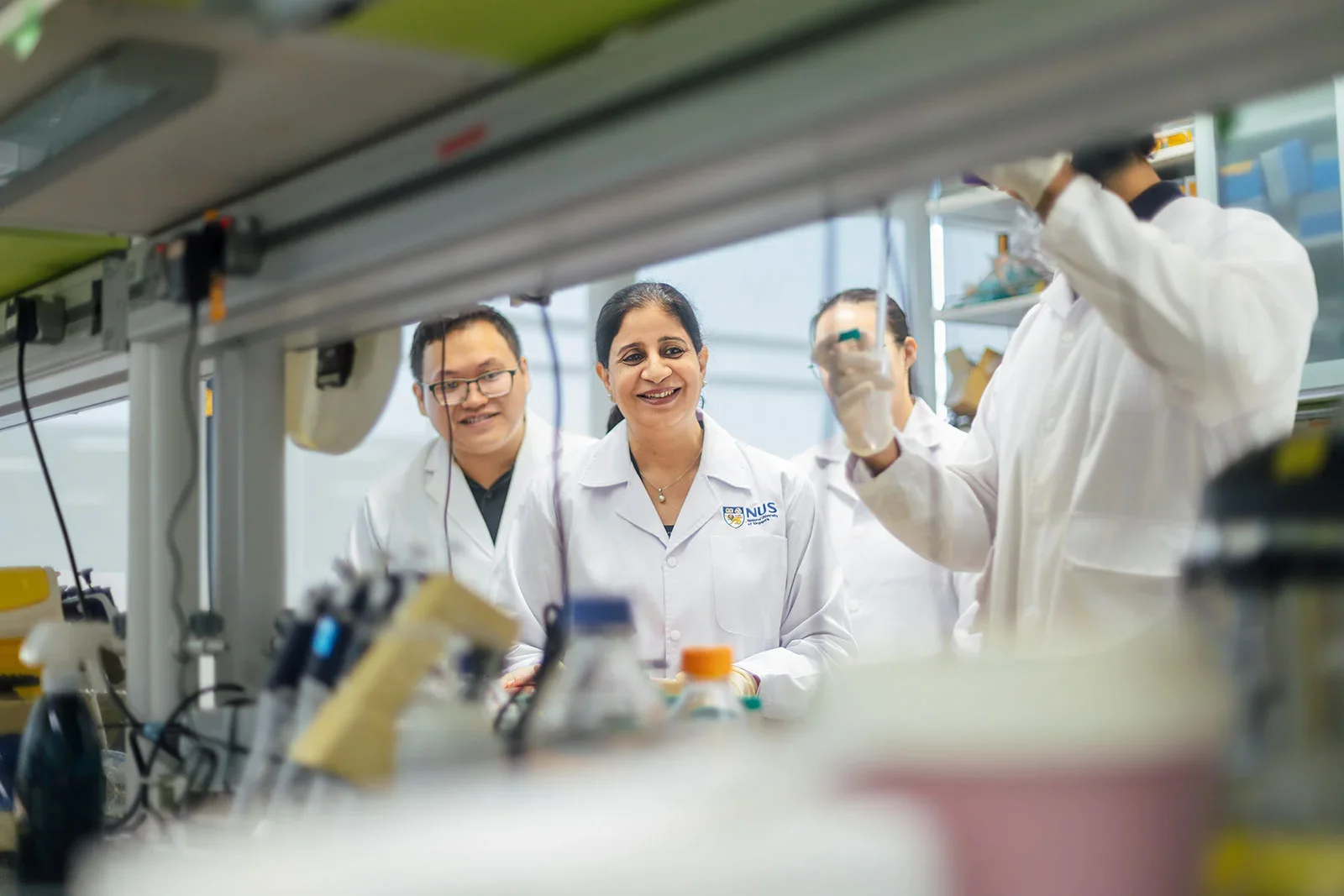 Prof Taneja and 3 other staff working at NUS Medicine.