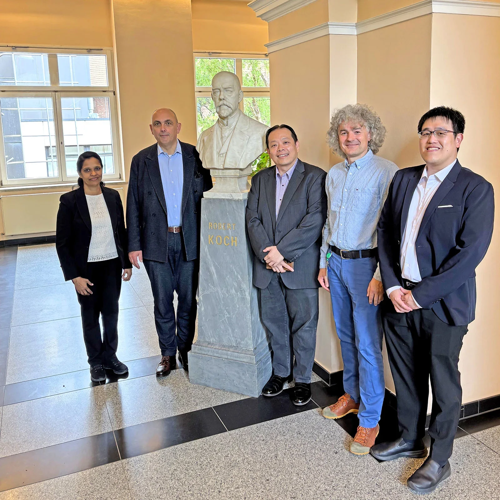 NUS Medicine and RKI representatives at the bust of Robert Koch at the RKI main campus. From left: Dr Tessy Joseph (NUS Medicine BSL-3 Core Facility Senior Assistant Director), Prof Dr Med Lars Schaade (RKI President), A/Prof Justin Chu Jang Hann (NUS Medicine BSL-3 Core Facility Director), Dr Andreas Kurth (Head RKI of BSL-4 Laboratory of the Centre for Biological Threats and Special Pathogens), Dr Tan Kai Sen (NUS Medicine BSL-3 Core Facility Research Director).